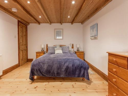 a bedroom with a bed and wooden floors at The Cottage - Uk10514 in Carbis Bay
