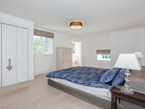 a white bedroom with a large bed and a lamp at Skene House Court in Dunecht