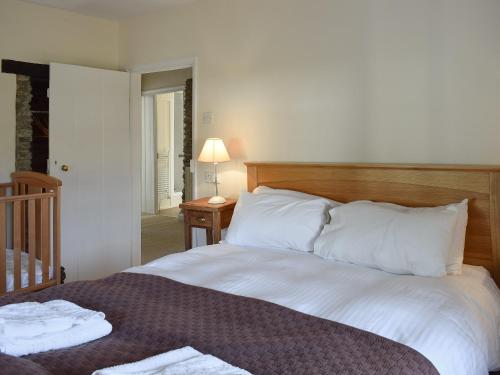 uma cama com lençóis brancos e almofadas num quarto em Royal Oak Farm em Winsford