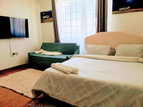 una camera con letto e divano verde di Teakwood a Eldoret