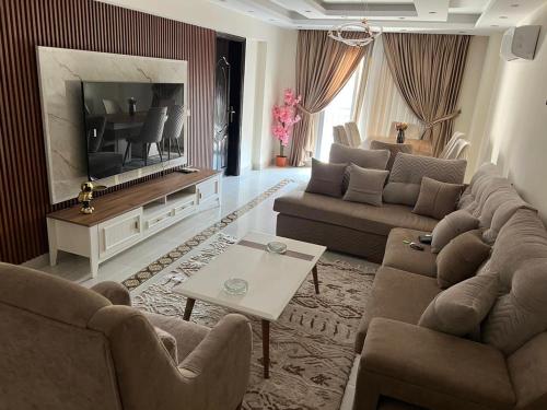 ein Wohnzimmer mit 2 Sofas und einem TV in der Unterkunft Marim tower in Kairo