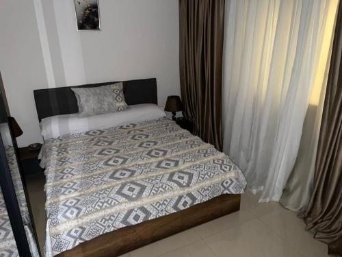 ein Schlafzimmer mit einem Bett mit einer Bettdecke darauf in der Unterkunft Marim tower in Kairo