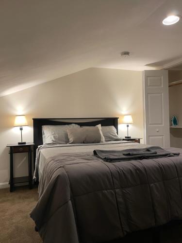 a bedroom with a large bed with two lamps at Downtown Private Rooms - Close to M&T, Orioles, Topgolf, Horseshoe Casino in Baltimore