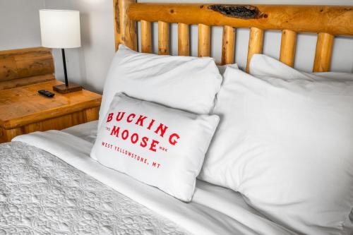 a pillow with a stuffing moose on it sitting on a bed at The Bucking Moose in West Yellowstone
