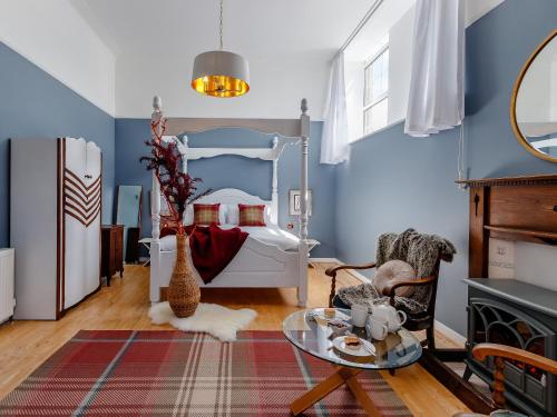 a bedroom with blue walls and a bed with a table at Torreagles in Mintlaw