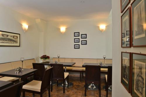 a restaurant with tables and chairs and pictures on the wall at Hotel Domstern in Cologne