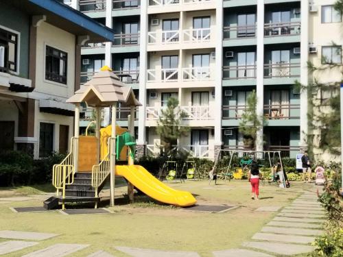 a playground with a slide in front of a building at Family Staycation in Tagaytay in Tagaytay