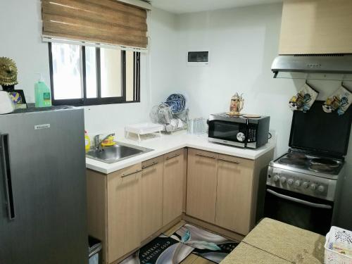 a small kitchen with a sink and a microwave at Family Staycation in Tagaytay in Tagaytay