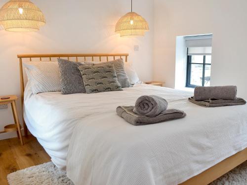 a bedroom with a white bed with towels on it at The Hen House-uk12928 in St. Just