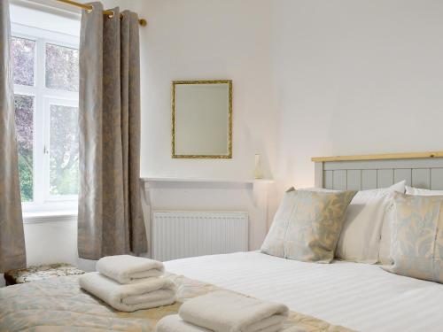 a bedroom with a bed with towels on it at Underhill Cottage in Arnside
