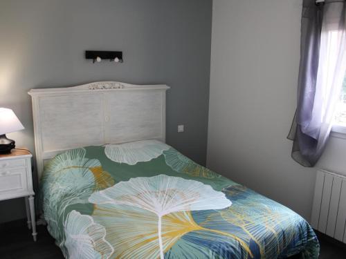 une chambre avec un lit avec une couette colorée dans l'établissement Charmante maison de plain-pied avec cour privée, proche de Verteuil-sur-Charente, WiFi, plancha, parking - FR-1-653-106, à Verteuil-sur-Charente