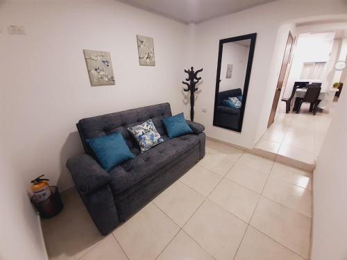 ein Wohnzimmer mit einem Sofa und einem Spiegel in der Unterkunft Apartamento en centro de Popayán in Popayan