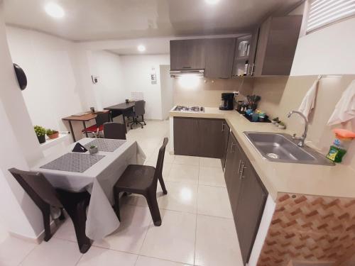 cocina con mesa, fregadero, mesa y sillas en Apartamento en centro de Popayán, en Popayán