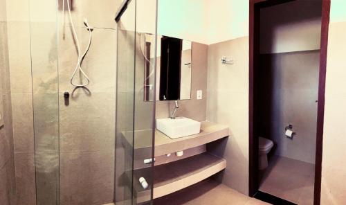 a bathroom with a shower with a sink and a toilet at Turtle Bay Village in São Miguel do Gostoso
