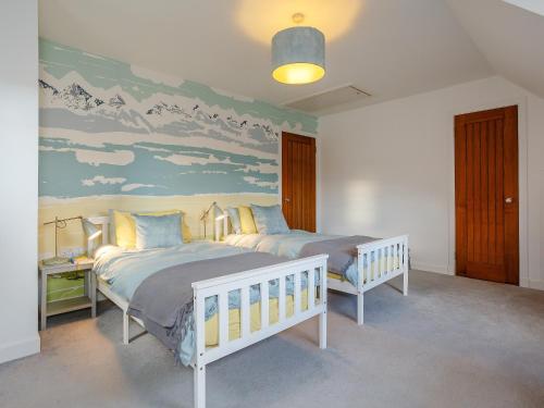 a bedroom with two beds and a painting on the wall at Cliff Cottage in Kalnakill