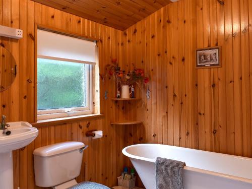a wooden bathroom with a tub and a sink at The Creagan in Corrie
