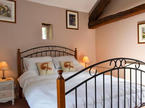 1 dormitorio con cama de metal con sábanas y almohadas blancas en Twinkleberry Barn, en Lorton