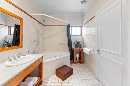 a white bathroom with a tub and a sink at Balgownie Estate Bendigo in Bendigo
