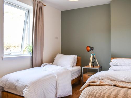 1 dormitorio con 2 camas y ventana en Watersreach en Collieston