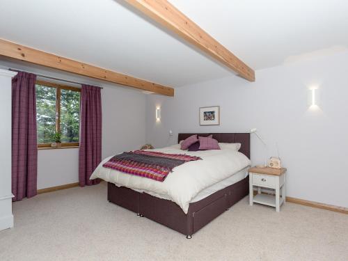 Un dormitorio con una cama grande y una ventana en Sands Farm Cottage, en Luddenden Foot