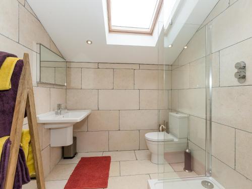 a bathroom with a toilet and a sink and a shower at Sands Farm Cottage in Luddenden Foot
