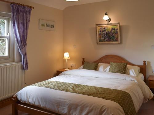 Un dormitorio con una cama grande y una ventana en Gwili Cottage en Llanfynydd