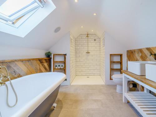 La salle de bains est pourvue d'une baignoire et d'une douche. dans l'établissement Turnip Cottage, à Newsham