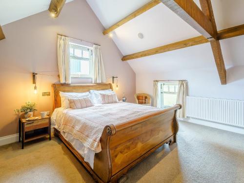 a bedroom with a large wooden bed in a room at Turnip Cottage in Newsham