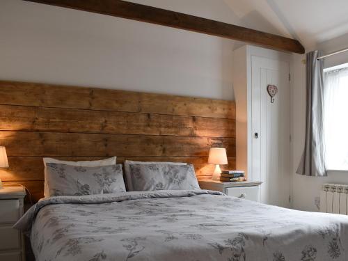 a bedroom with a large bed with a wooden headboard at Willow in Harrietsham