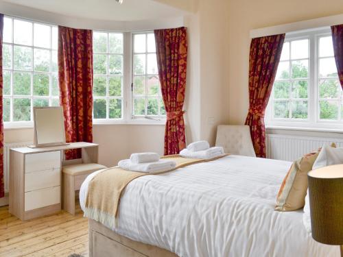 a bedroom with a large bed with red curtains at The Arches in Scarborough