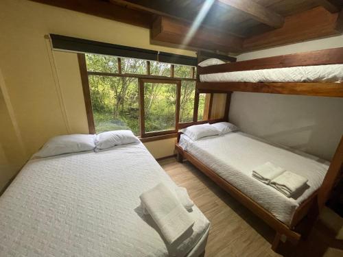 two bunk beds in a room with a window at Hostería CASA SAN LUIS in Quito