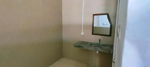 uma casa de banho com um lavatório e um espelho em Scar Reef Homestay em Jereweh