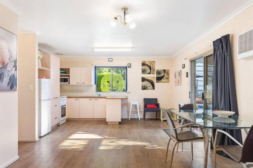 a kitchen and dining room with a table and a dining room at Relaxed Urangan Living at the Poolside Bungalow in Hervey Bay
