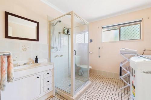een badkamer met een douche, een wastafel en een toilet bij Relaxed Urangan Living at the Poolside Bungalow in Urangan