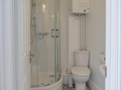 a bathroom with a toilet and a glass shower at Sandgate Apartment in Sandgate