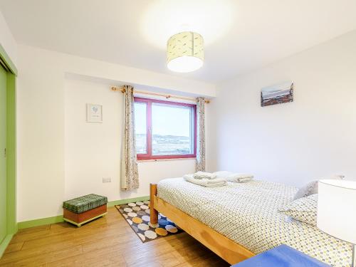 a white bedroom with a bed and a window at Riof Bay - Uk31251 in Valtos