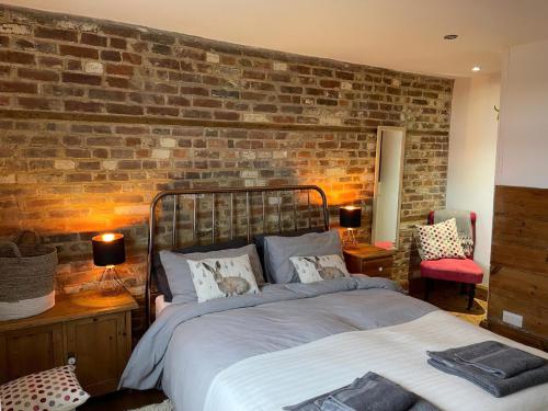 a bedroom with a brick wall and a bed at Jacks House in Hastings