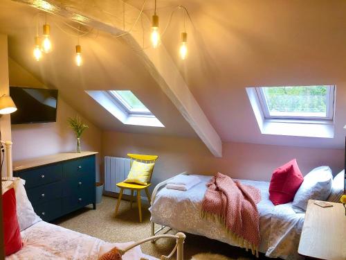 1 dormitorio en el ático con 2 camas y 2 tragaluces en Lemon Cottage en Bickington