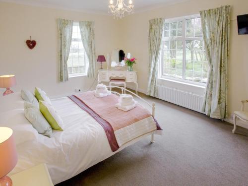 a bedroom with a large white bed and a table at Todburn East in Longhorsley