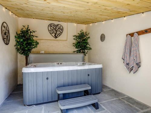 a blue bath tub in a bathroom with two plants at Knoll Cottage - Uk31171 in Brent Knoll