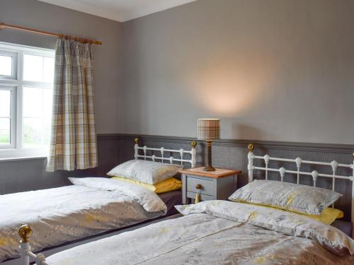 - 2 lits dans une chambre avec fenêtre dans l'établissement Prior Dene Cottage, à Staintondale