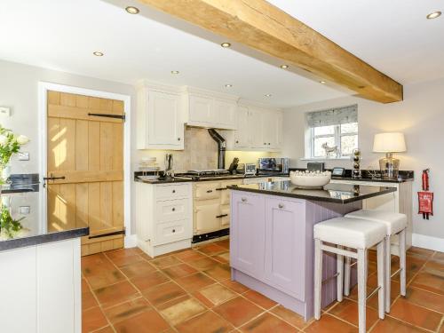 a kitchen with white cabinets and a counter top at Gilbertson Cottage in Wheldrake