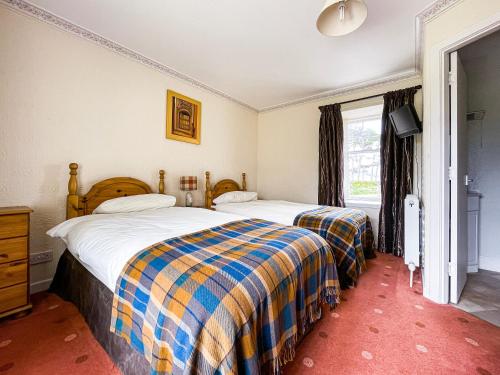 a bedroom with two beds and a window at Fourpenny Cottage - Uk34744 in Embo