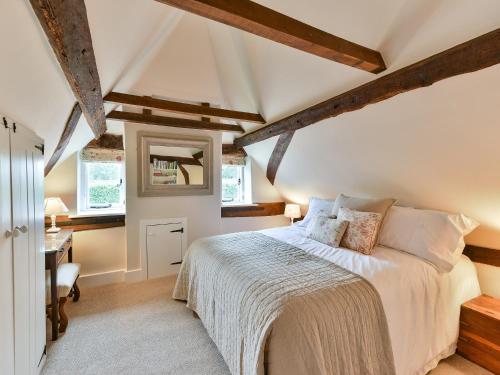 een slaapkamer met een bed en een bureau bij Peppercorn Cottage in Cheriton