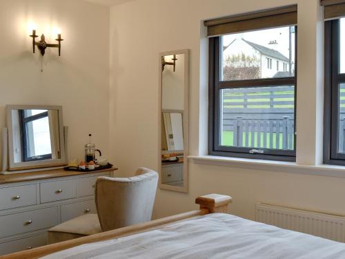 a bedroom with a bed and a desk and a window at Thistlebank in Banknock