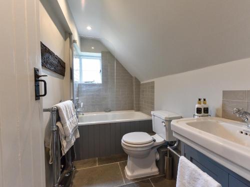 a bathroom with a toilet and a tub and a sink at Peppercorn Cottage in Cheriton