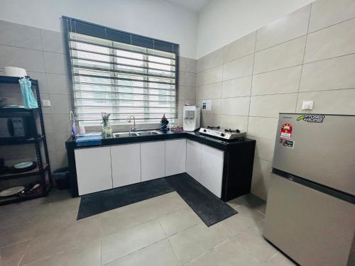 uma cozinha com um lavatório e um frigorífico em Insyirah Homestay Melaka em Malaca
