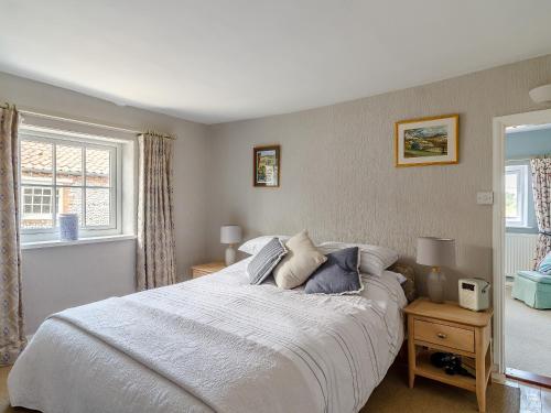 a bedroom with a large bed and a window at 42 Temple End in Blakeney