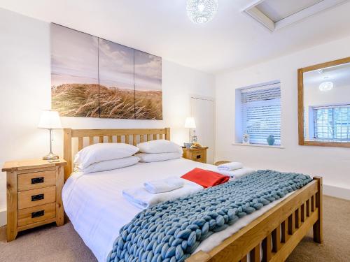 a bedroom with a large bed and a painting on the wall at Pebble Cottage - Uk32243 in Aberdyfi