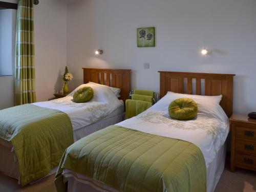CuryにあるEglos Derry Farm Cottage - E4597のベッドルーム1室(ベッド2台、緑のシーツ、枕付)